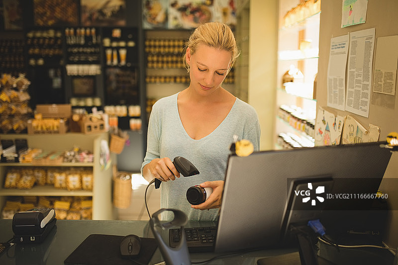 女销售员在商店扫描产品图片素材