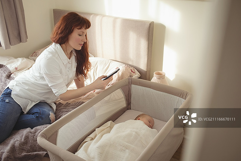 母亲拍摄在婴儿床里睡觉的宝宝图片素材