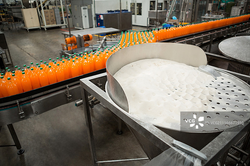 生产线上的橙色冷饮瓶俯视图图片素材