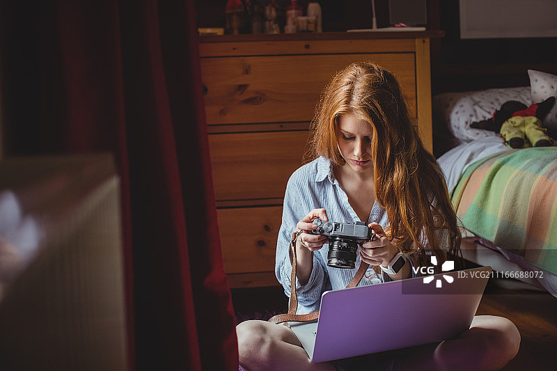 女人在家看数码相机里的照片图片素材