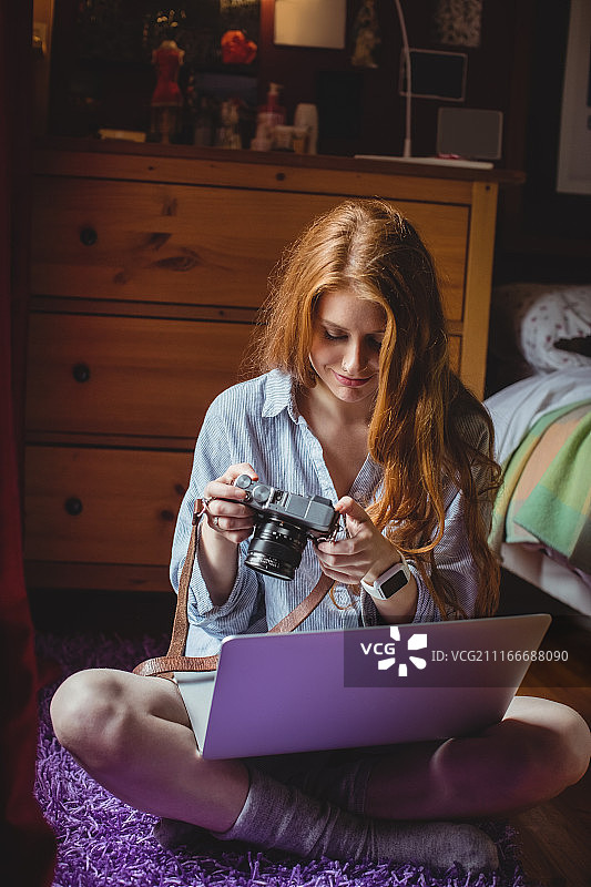 女人在家看数码相机里的照片图片素材