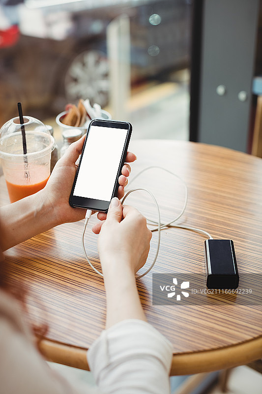 在自助餐厅使用充电宝为手机充电的商人图片素材