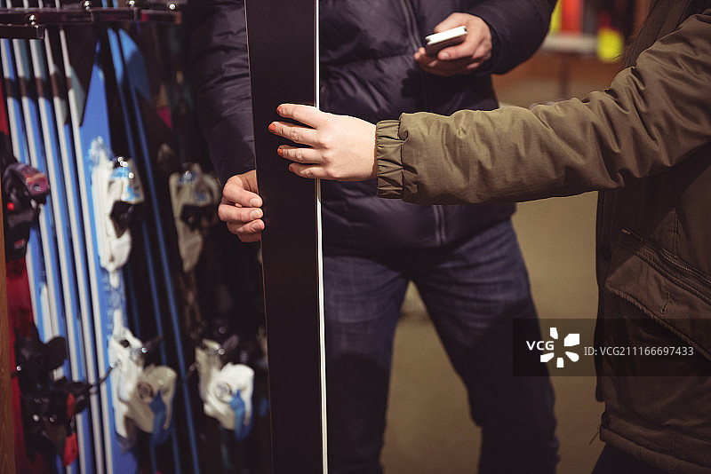 情侣在商店里挑选滑雪板图片素材