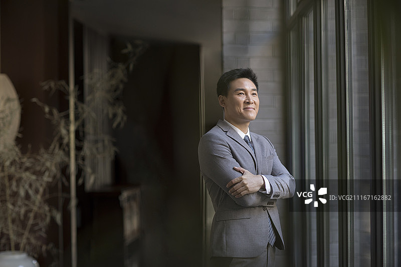 自信的商务男士看向窗外图片素材