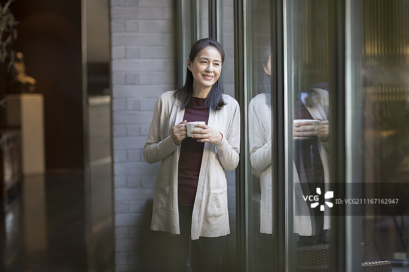优雅的中年女子喝咖啡图片素材