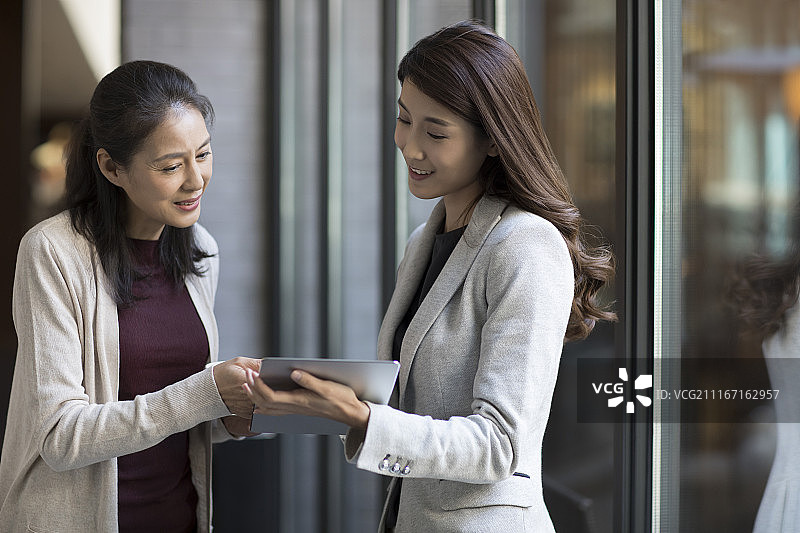 优雅的中年女子与年轻商务女子交谈图片素材