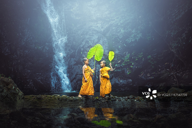 两个男孩站在瀑布旁图片素材
