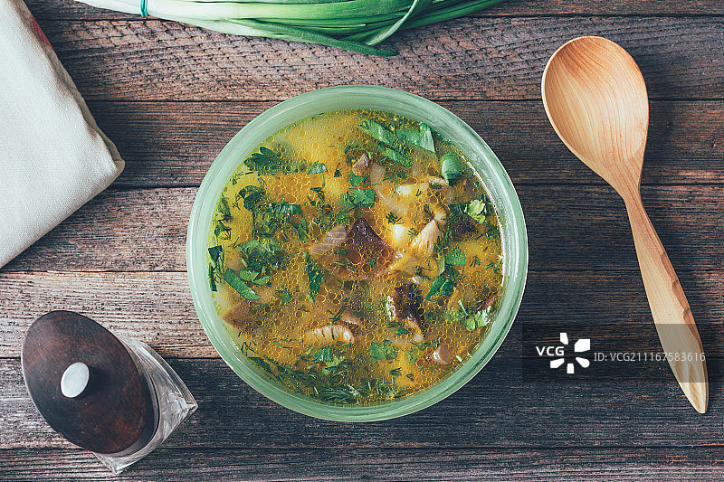 碗里的蘑菇汤、绿色洋葱、木勺和旧胡椒研磨器图片素材