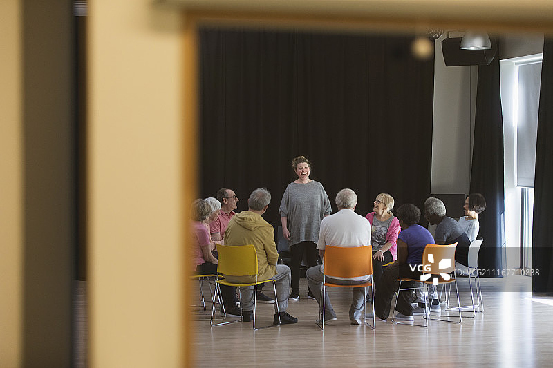 妇女在社区中心带领老年人进行小组讨论图片素材