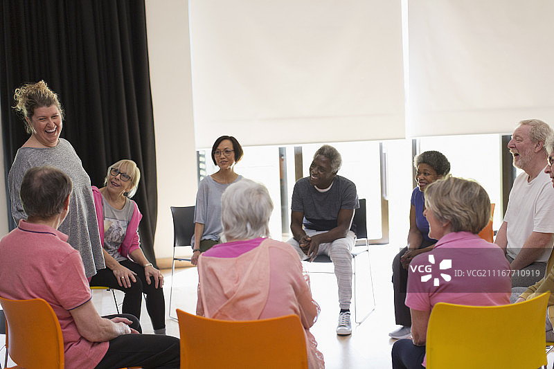 在社区中心围成一圈欢笑的活跃老人图片素材