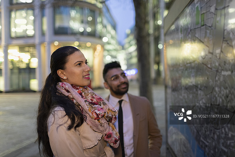 商务人士夜晚在城市街道上看地图图片素材