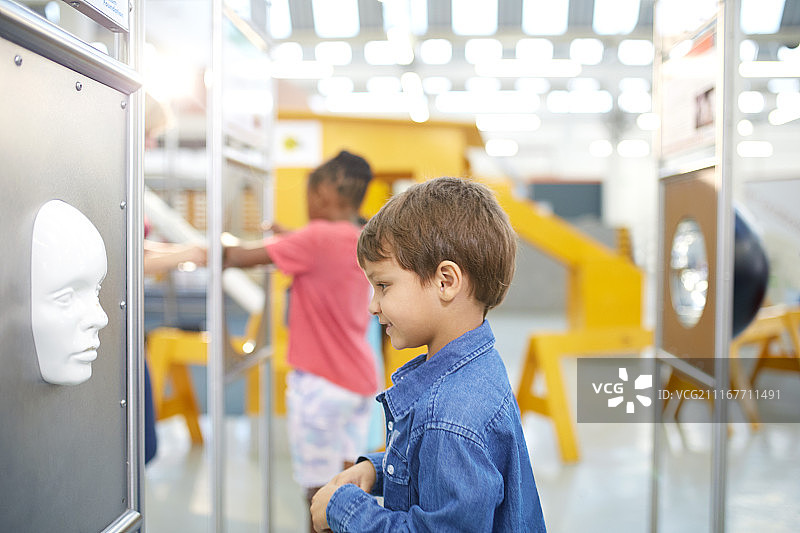好奇的男孩在科学中心看脸图片素材