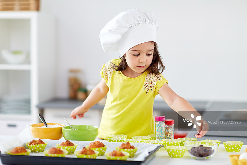 家庭亲子烘焙：小女孩在家烤纸杯蛋糕图片素材