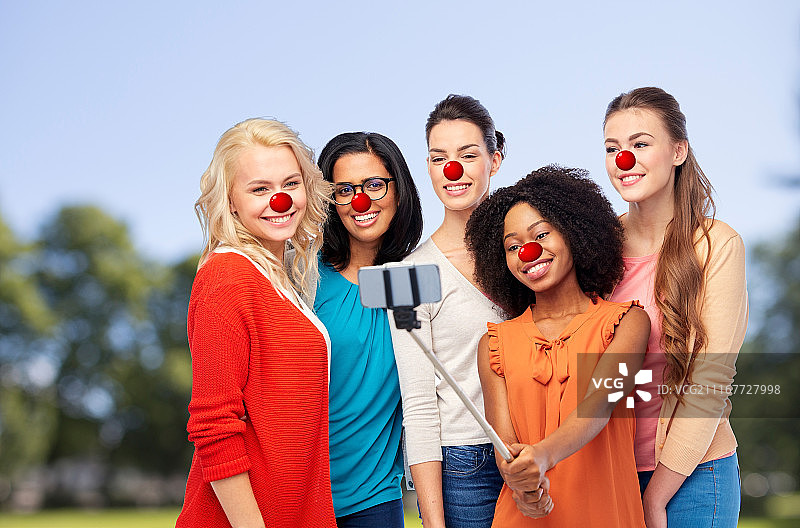国际红鼻子日，一群快乐微笑的女性用智能手机自拍图片素材