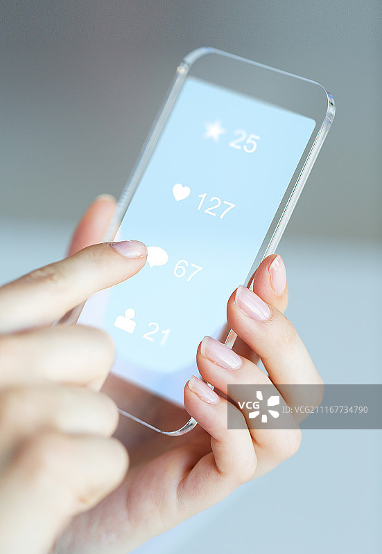 现代科技与人物概念：女性手持透明手机展示社交媒体图标图片素材