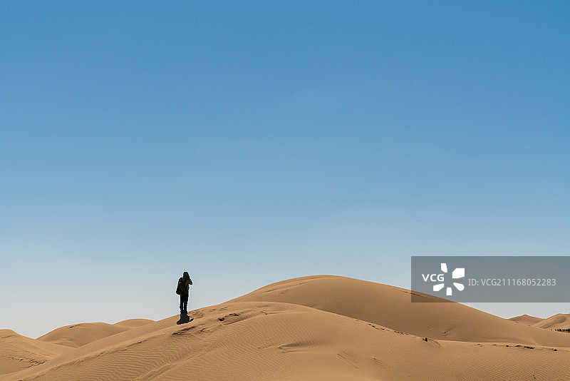 库布齐沙漠中徒步的背包客图片素材