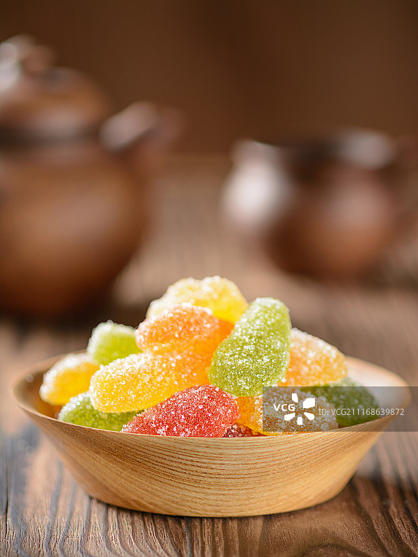 木桌上的木盘装有橘子酱，背景是水壶和杯子图片素材