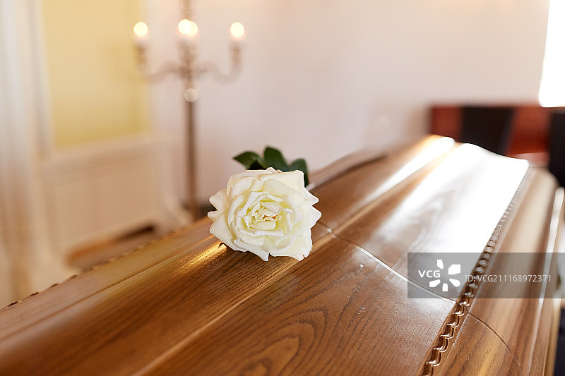 葬礼和哀悼概念：教堂木制棺材上的白玫瑰图片素材
