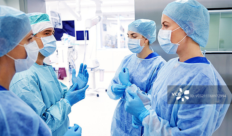 手术医学概念：外科医生在医院手术室交谈并准备手术图片素材