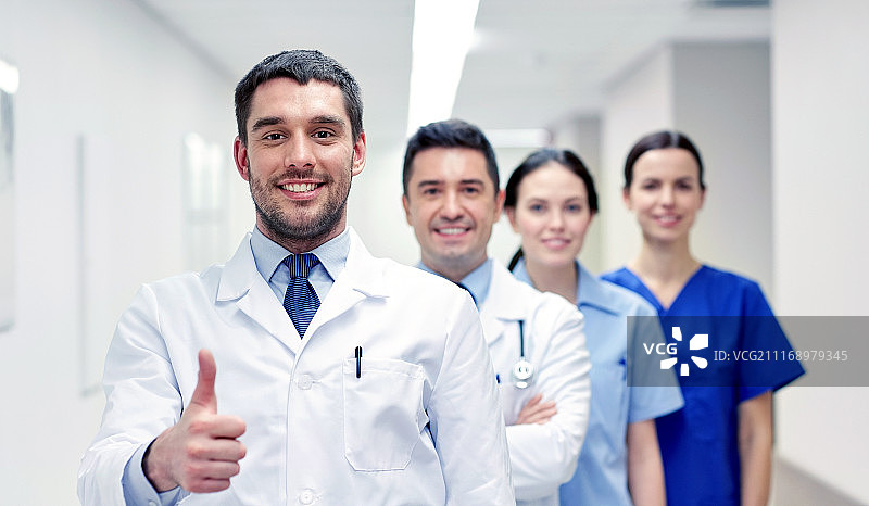 职业、人物、医疗保健：医院走廊里一群快乐的医务人员或医生竖起大拇指图片素材