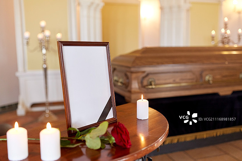 葬礼与哀悼概念：带黑丝带的相框、燃烧的蜡烛和教堂里的棺材图片素材