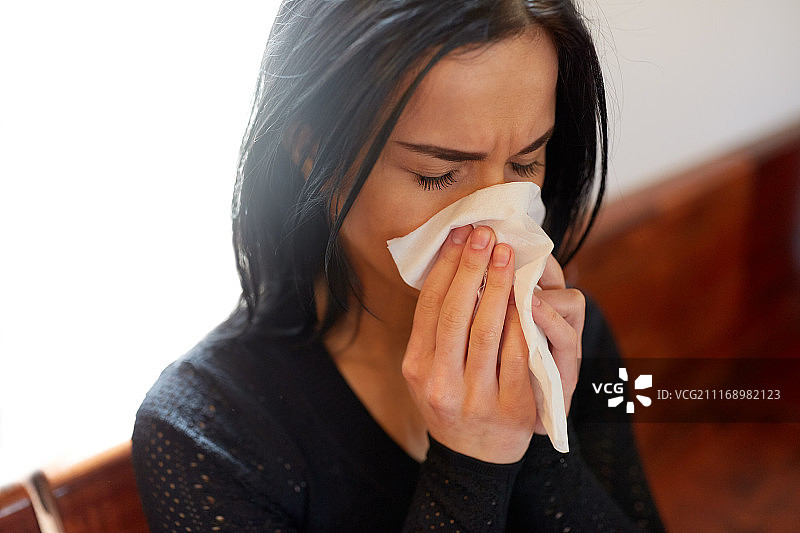 葬礼上悲伤哭泣的女人用纸巾擦鼻子图片素材