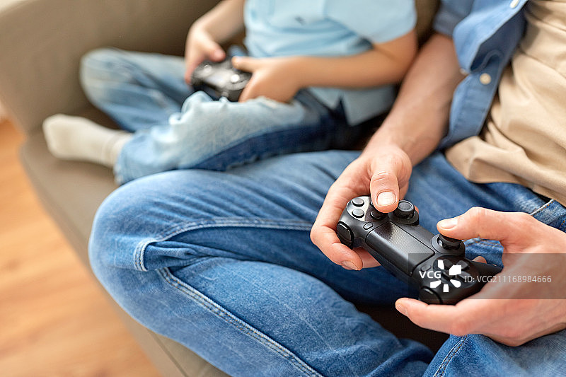 父子亲情：父亲和儿子在家玩电子游戏图片素材
