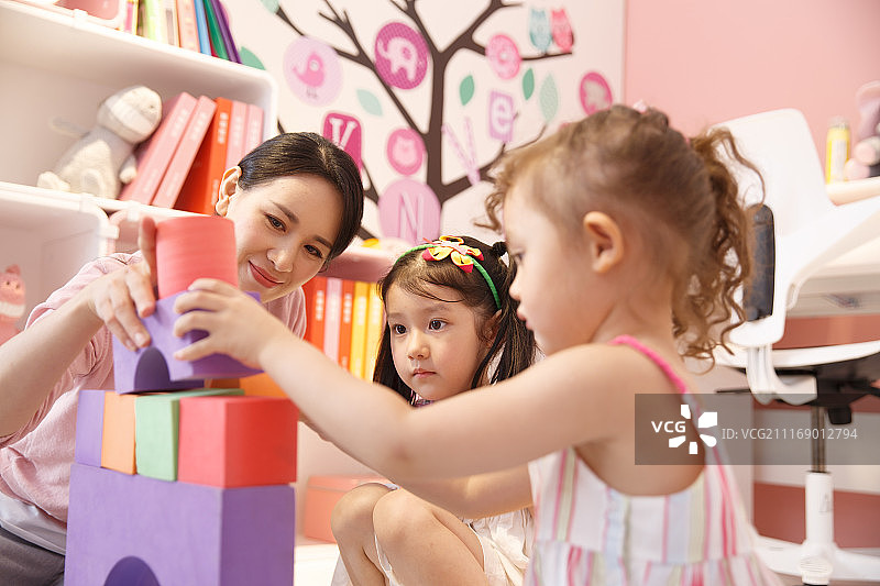 两个小女孩和妈妈在卧室玩耍图片素材