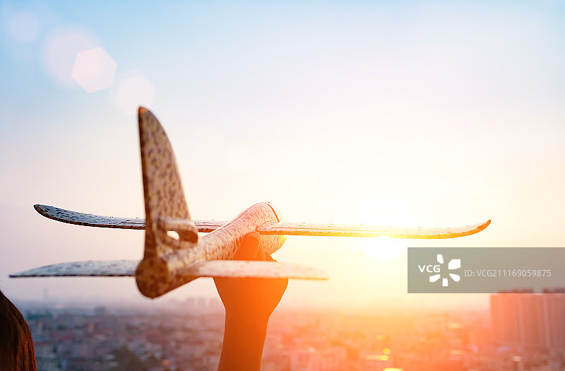 小孩手持飞机飞向天空图片素材