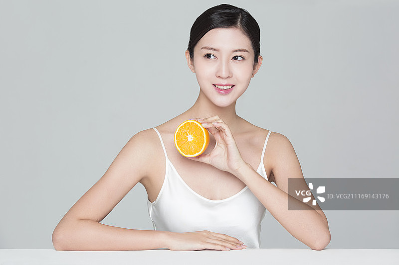 美丽年轻的女子与橙子图片素材