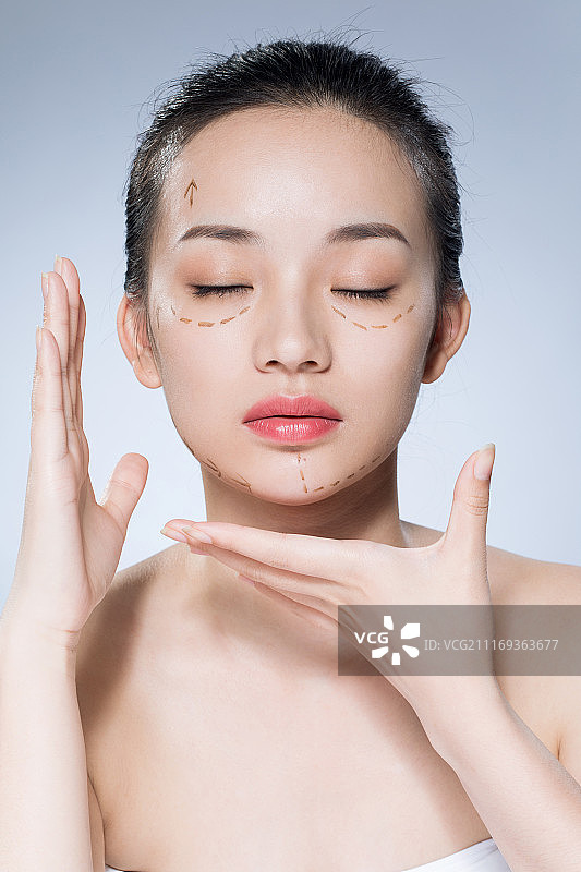 年轻女性在脸上画上虚线图片素材