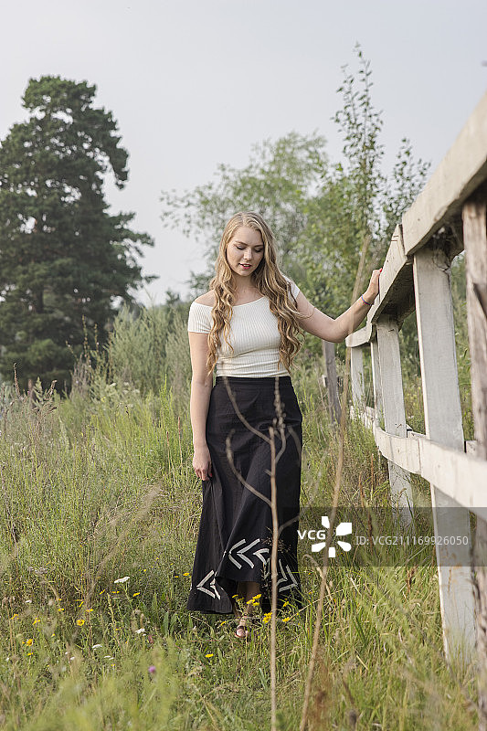 站在栅栏旁的年轻女人图片素材