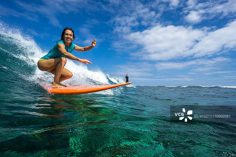 年轻女子在海浪上冲浪图片素材