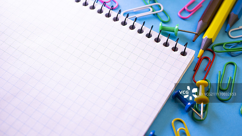 办公室桌面上带有铅笔和回形针的笔记本图片素材