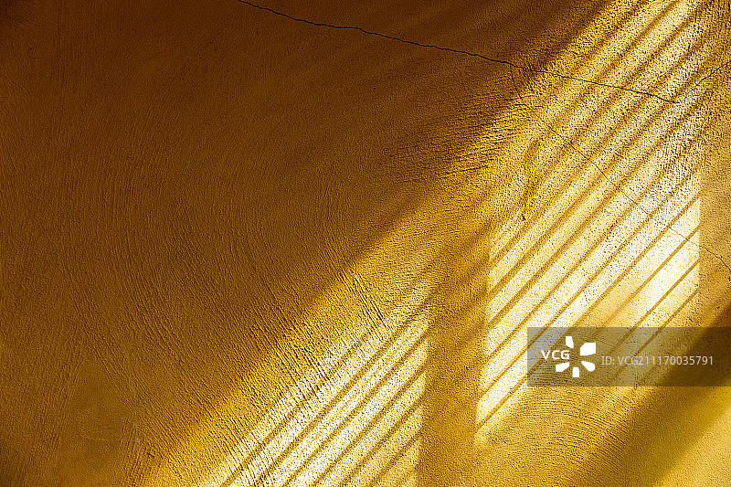 沐浴在午后阳光下的黄色水泥墙图片素材