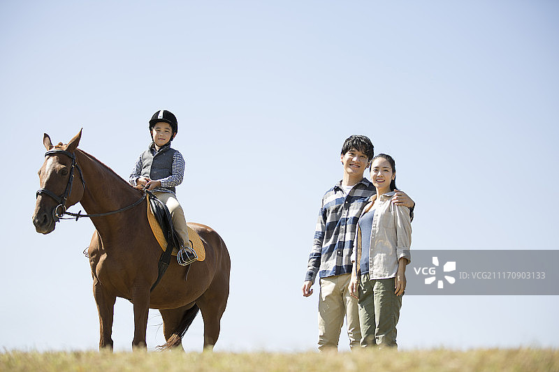 父母教孩子在户外骑马图片素材