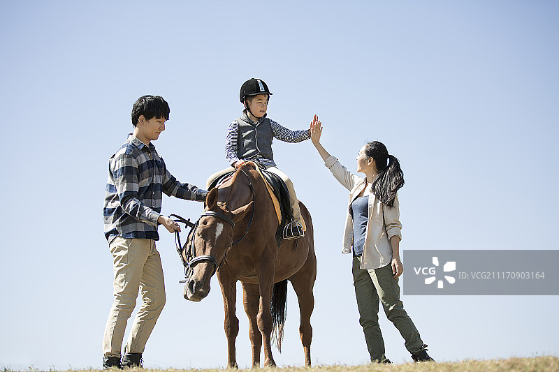 快乐一家人在草地骑马图片素材