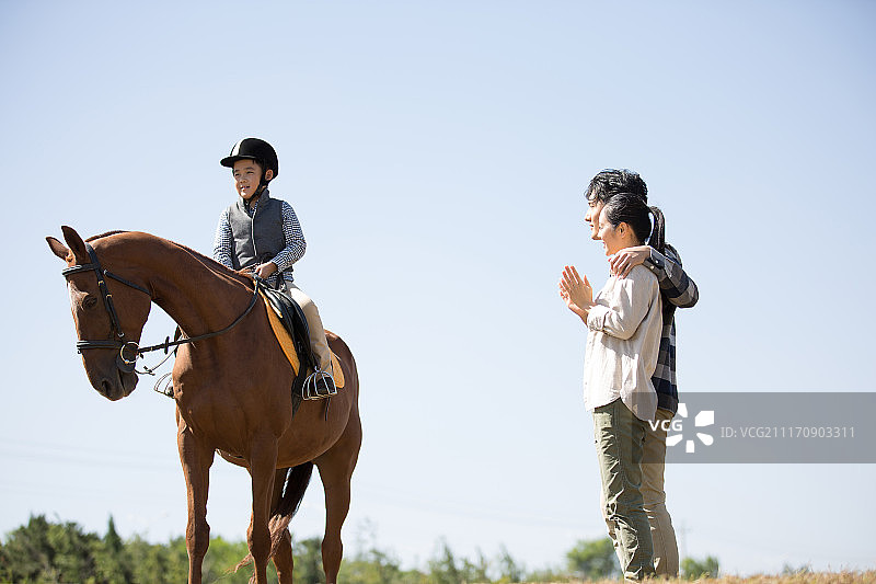 快乐一家人在草地骑马图片素材