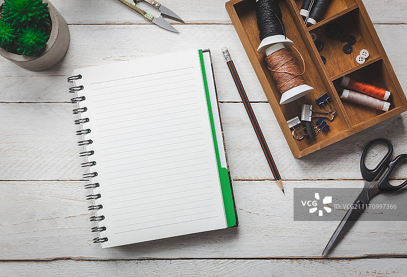 俯视：裁缝概念配件，裁缝工具剪刀正在裁剪图片素材