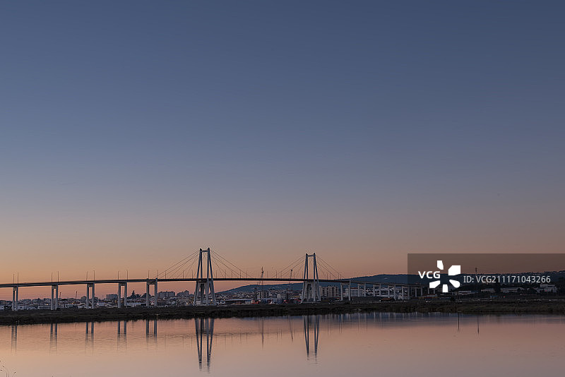 日落时分晴空下悬索桥的远景图片素材