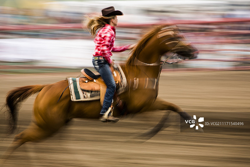 女牛仔在科罗拉多州帕戈萨斯普林斯骑马参加绕桶赛图片素材