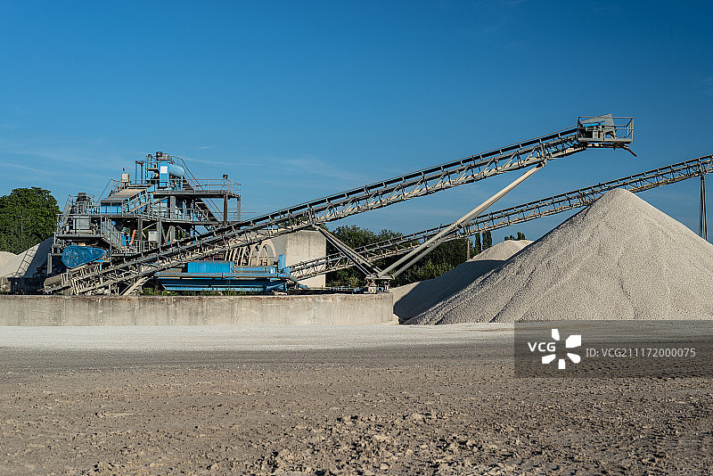 蓝色天空下砾石堆上的传送带图片素材