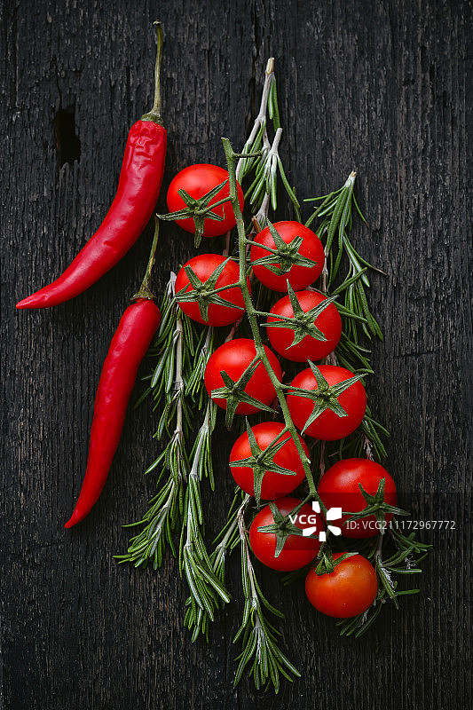 深色背景下的迷迭香辣椒小番茄美食背景图片素材