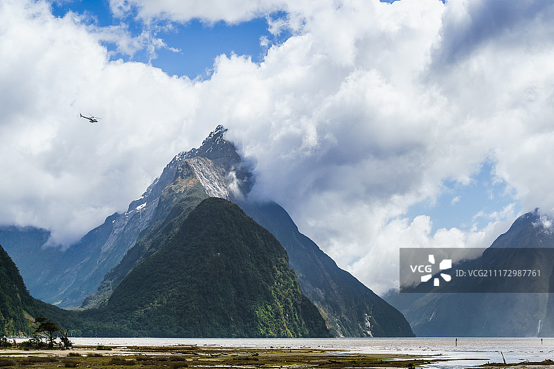 飞过米尔福峡湾主教峰的直升机图片素材