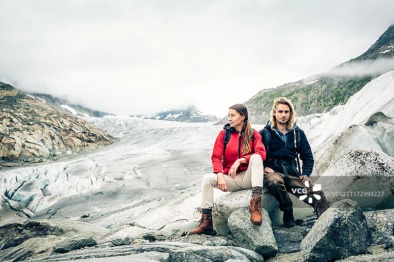 年轻情侣在瑞士阿尔卑斯山徒步旅行图片素材