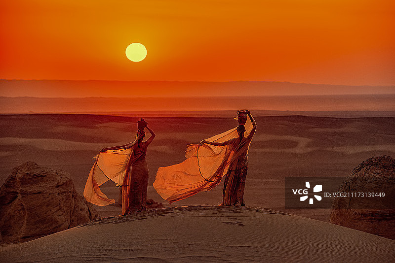 沙漠夕阳下异域风情的女子图片素材