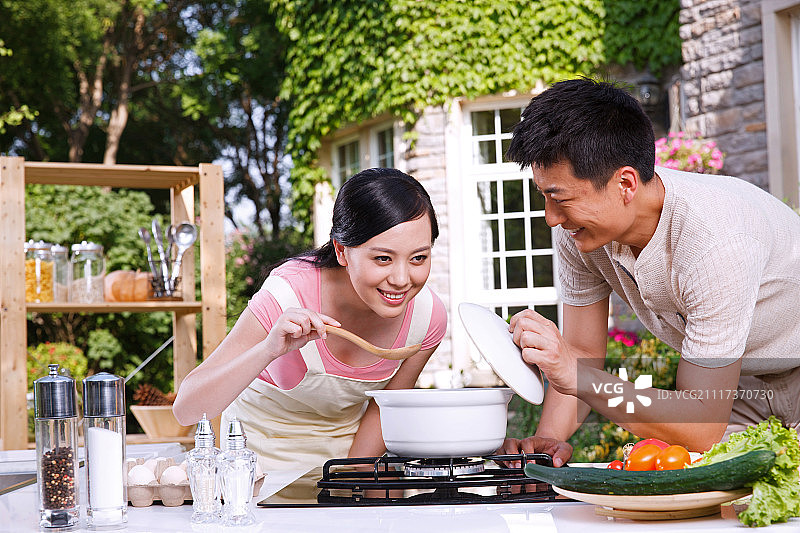 年轻夫妇在户外厨房做饭图片素材