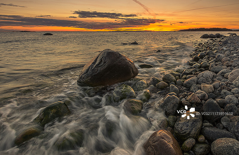 日落时分海滩上的岩石和鹅卵石景色图片素材