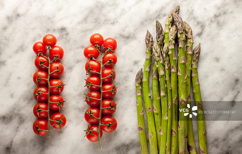 大理石背景上的芦笋和樱桃番茄图片素材