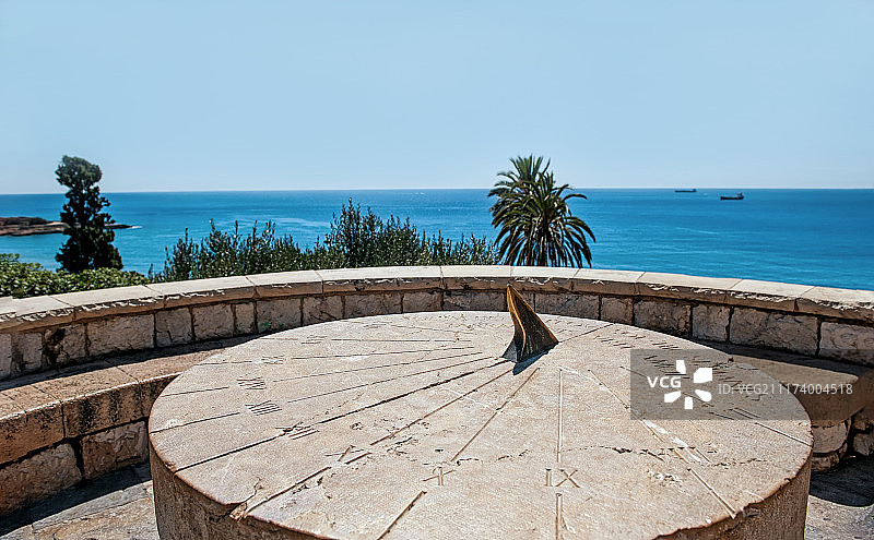 晴朗无云的日子里，山丘上大型圆形石制罗马日晷图片素材